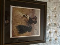 Framed print of three dogs in a marsh setting with a wooden frame, medium size.