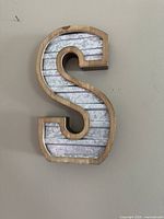 Front view of letter 'S' wall decor showing wood frame and metal insert with a galvanized metal look.