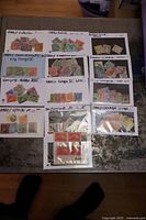 Photo showing all 13 stock cards arranged on a flat surface with handwritten labels indicating the country and era of stamps, including Canada, UK, Spain, Switzerland, USA.