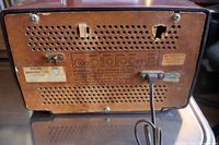 Rear panel of the radio showing vent holes, labels, Philips Industries Ltd. logo sticker, and attached power cord.