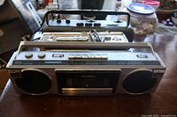 Front view of three vintage boomboxes stacked showing overall condition and details