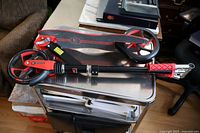 Folded Dart Street Runner scooter showing red and black color, large wheels, collapsible handlebar and frame.