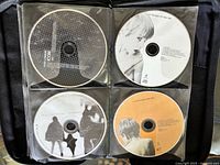 Four CDs in wallet sleeves, grayscale geometric, female portrait, silhouette cover, orange label disc