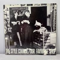 Front cover with title and image of band in shop