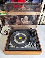 Turntable with dust cover open showing platter and tonearm