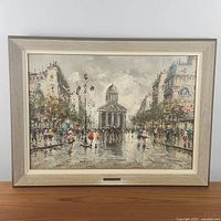 Framed oil painting of Parisian street scene showing full composition and light wood-look frame