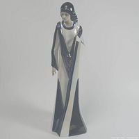 Front view of the Azia porcelain woman figurine showing facial features, upper body and flowing robe in navy and ivory.