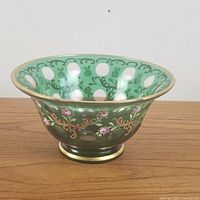 Side angle photo showing green cut-to-clear glass with oval cutouts and hand-painted pink floral and gold scroll designs.