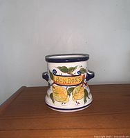 Front view of the Chino hand painted ceramic jar showing lemon, cherry, and sign 'BONBONS'.