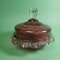 Cranberry red glass candy dish with clear ruffled edge viewed from side showing lid and finial knob