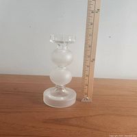 Photo showing the frosted and clear glass candle holder standing next to a ruler indicating its height about 7 inches