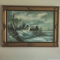 Full front view of large oil painting in ornate gold frame depicting snow-covered barn, bare tree and windmill under cloudy sky.