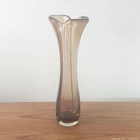 Front view of tall amber hand-formed glass vase showing shape and color