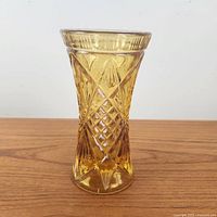 Side view of amber glass vase showing pressed diamond and fan pattern with flared rim
