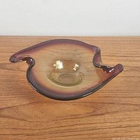 Front view of amberina gradient hand-blown glass bowl showing organic sculptural, flowing shape with shallow center and curved edges.