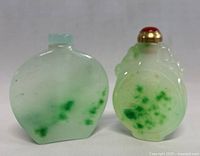 Pair of vintage Chinese carved jade snuff bottles, showing both front and side views to reveal colors, carving details and stoppers.
