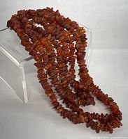 Front view of the amber necklace showing multiple strands and natural amber chips.