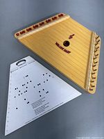 Melody Harp showing body with strings and included sheet music.