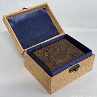 Hinged burlap-covered box open, showing interior blue velvet lining and stone seal