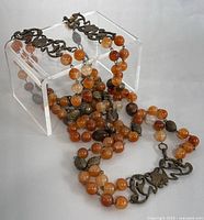 Full view of the necklace arranged on a clear stand to show overall length and bead color variation.