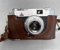 Front view of the Atlas 35mm film camera in brown leather case showing lens and viewfinder