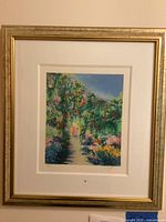 Framed lithograph featuring a garden path scene with figures walking, with visible matting and gold-tone frame.