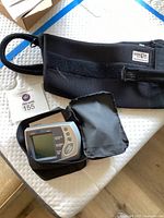 Black arm sling by Lerman and Son with attached adjustable strap and label