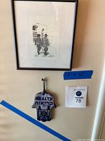 Framed signed pencil drawing by Eileen Salzman and decorative Chamsa hand hanging below with 'Health' inscription.