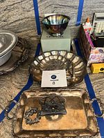 Overview of all items on countertop: bowl on box, scalloped dish, napkin holder and tray