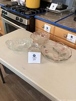 Photo of the set showing the oval and round Mikasa Carmen crystal bowls and small jam jar on a table with kitchen background.
