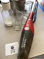 Photo of Dirt Devil handheld vacuum cleaner with glassware and stock pot in background