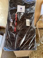 Black protective cover for Drive brand wheelchair, sealed in plastic packaging showing branding and lot number.