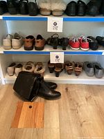 Shelving with multiple pairs of ladies footwear including boots, moccasins, sneakers, wedges, slippers, casual shoes