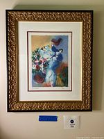 Full view of the framed lithograph, showing artwork with colorful abstract bride and groom figures, floral elements, and ornate gold frame.