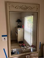 Full view of large rectangular mirror showing reflective surface and partial surrounding room.