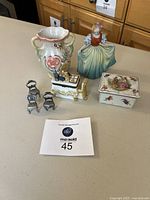 Grouped photo showing all items in the lot including the porcelain figurine, pewter chairs, lusterware vase, and two trinket boxes on a table.