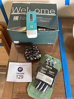 No No Hair Removal System unit on top of its green box, a black stone pen holder with multiple holes, and a white paper with lot number on a wooden table.