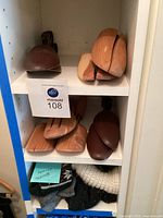 Shoe stretchers, shoehorns, and winter socks on shelf inside cabinet