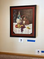 Painting hanging on wall showing the full artwork and frame, revealing the still life scene and the condition of the frame.