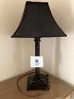 Front view of the black desk lamp with square-based black shade and attached power cord.