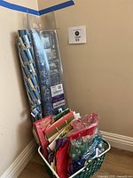 View of all items including several rolls of Hanukkah wrapping paper and a basket filled with gift bags, tissue paper, and bows.