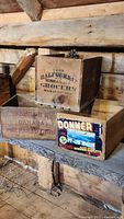 Three vintage wooden boxes stacked together, showing markings of Donner, Ralfour & Co., and Benson's, placed on wooden shelf.
