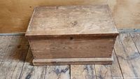Front view of the antique wooden blanket box with flat top and keyhole.