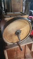 Side view of the wooden barrel churn showing hand crank and metal bands