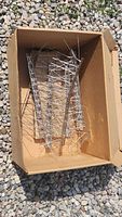 Box containing several metal bird deterrent spikes approx 15 inches long with pointed metal spikes to prevent birds from landing.