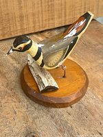Front angle view of the killdeer bird decoy showing painted details and wooden base with driftwood.