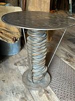 Oblique side view of round top and spiral disc column supported by three rods