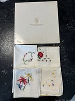 Top view showing the original cream box with The J.L. Hudson Company logo and four folded embroidered handkerchiefs beneath it.