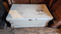 Top closed view of rectangular white wooden blanket box showing chipped paint and rustic condition.