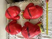 Top-down photo showing all four red boxing gloves grouped on a surface, highlighting Spalding branding.